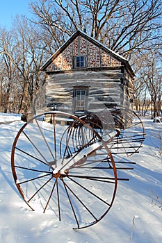 Antique rake and cabin in snow