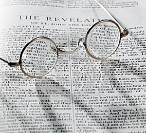 Antique reading glasses on page of bible photo