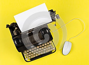 Antique retro mechanical typewriter with modern computer mouse on yellow background - digitalization, digitization or