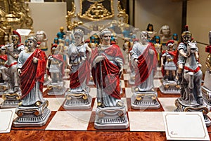 Antique roman figure chess set for sale displayed in an antiquities shop window photo