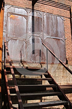 Antique rusted industrial doors at top of stairs