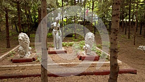 Antique sculptures among fir trees in courtyard