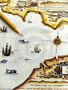 Esotico, il turismo e i viaggi lontani tema di Un'immagine di un marrone matita punta a un antico mare mappa o carta nautica mostrando una rosa dei venti, le navi a vela, di mare, balene e squali.