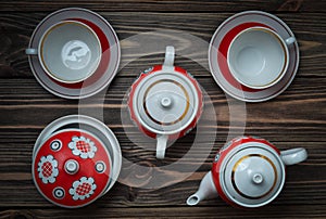 An antique set of ceramic teapots, cups, saucers on a wooden table. Tea ceremony.