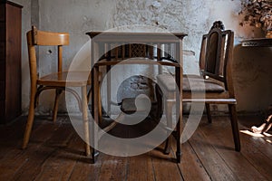 Antique set of old table and chair interior with vintage grunge white wall texture decoration with blank space for text.