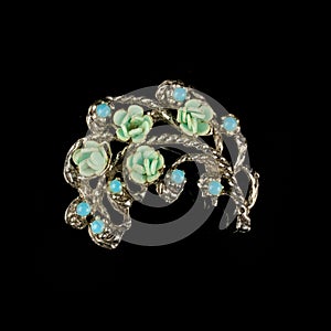 Antique silver brooch with precious stones and crystals in the shape of a flower.