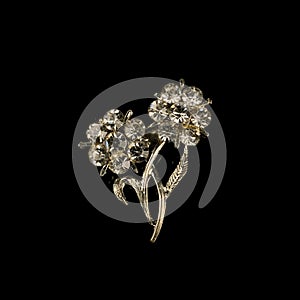 Antique silver brooch with precious stones and crystals in the shape of a flower.