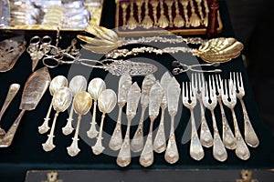 Antique silver Cutlery, spoons, forks, knives on the shelf of the flea market