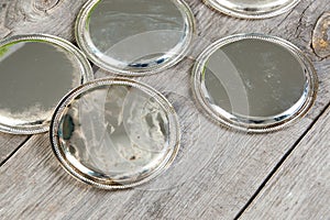 Antique silverplated coasters on wooden background