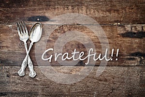 Antique Silverware and Grateful text over Wooden Background