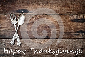 Antique Silverware and Happy Thanksgiving text over Wooden Background