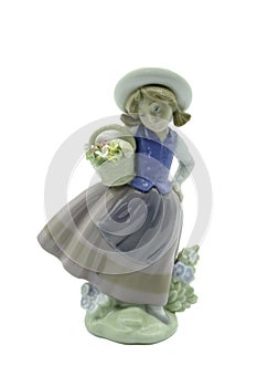 Antique Small porcelain figure of a girl in blue brown and white clothing carrying a vase of yellow pink and white flowers