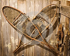 Antique Snow Shoes Hanging on Wooden Wall photo