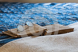 Antique Spectacles on Book on Bed