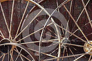 Antique spoke wheels against a wooden building