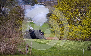 Antique Steam Passenger Train Approaching on a Single Track Blowing Smoke