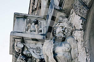 Antique stone Atlas sculpture on the wall of a building in Saint Petersburg, dramatic male statue close up