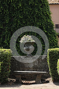 Antique stone vase with flowers in a garden