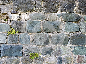 Antique stone wall. Background from a gray stone. The architecture of antiquity. Bricks of the Middle Ages. Remains of the castle