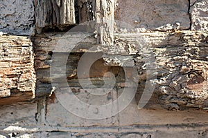 Antique stone wall surface with decayed wooden part is close