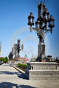 Antique street lamp and blue sky on background. Large street lamp with five lamps