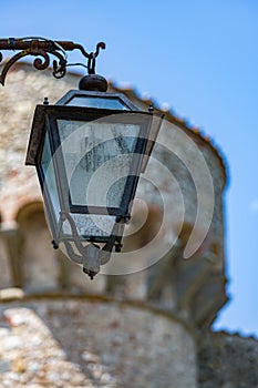 Antique street lamp in front of stone like castle building photo
