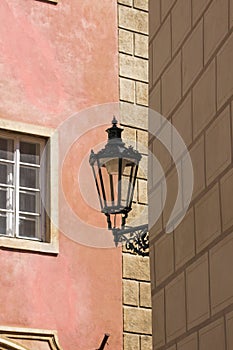 Antique street lantern hanging on wall in the old town of Prague, Czech Republic. Old street light against pink wall.