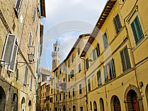 Antique street of Sinea with Mangia tower in background. Siena, Italy