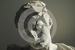 Cracked classical bust in dramatic lighting