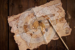 Antique-style world map with a pencil on the wooden table.