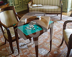 Antique table with built-in domino game. Situated in a classically decorated room