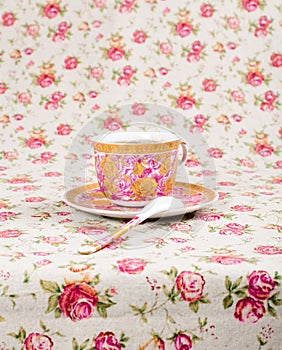 Antique tea cup full of tea on floral background