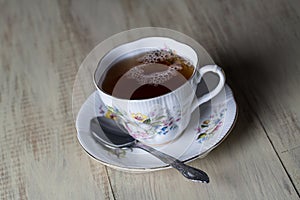 Antique Tea Cup Full of Tea on Wood Background