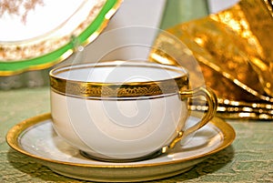 Antique teacup on saucer with fancy gold edge