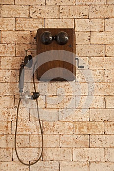 Antique telephone on brick wall.