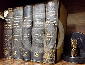 Antique textbooks on wooden shelf. Treaty of Practical Pharmacy by Hermann Hager