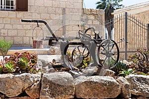 Antique tool - plow for plowing - hangs as decorations on a tree in the garden of the Deir Al-Mukhraqa Carmelite Monastery in