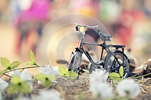 Antique toy bike placed on straw and decorated with flowers