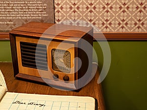 Antique transistor radio sitting in a child`s room with a diary