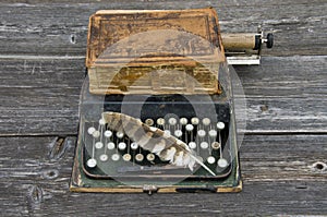 Antique typewriter with old book Bible and bird feather