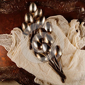 Antique, vinage cuterly spoons on silver tray with napkin