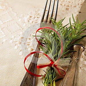 Antique, vintage cutlery with rosemary decorated on a table