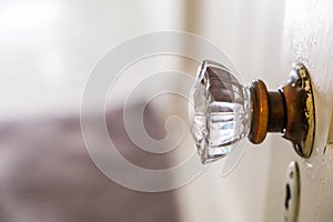 An antique vintage glass doorknob to a narrow bathroom in a small cottage house