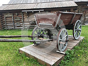 Antique vintage Russian rural peasant cart in the yard of a wooden house