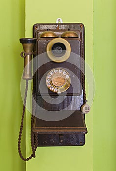 Antique vintage telephone green background.