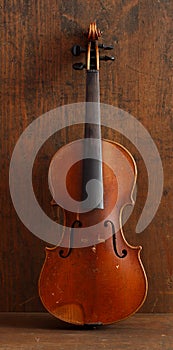 Antique violin for restoration on brown wood background