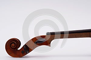 Antique violin scroll with pegs and neck on white background