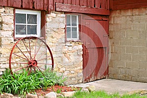 Antique Wagon Wheel Leaning on Old Stone Barn Wall