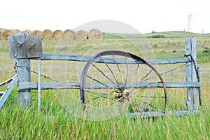 Antique wagon wheel leans against a fence in Montana.