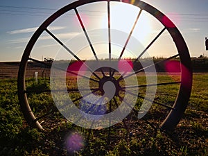 Antique Wagon Wheel Silhouetted in the Sunset